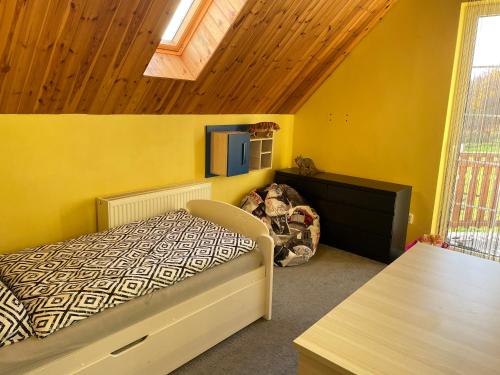 a bedroom with a bed and a yellow wall at Veselka in Dolní Bousov