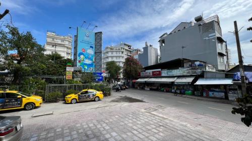 a city street with two yellow taxis parked on the street at Silk Hong Ha airport hotel in Ho Chi Minh City