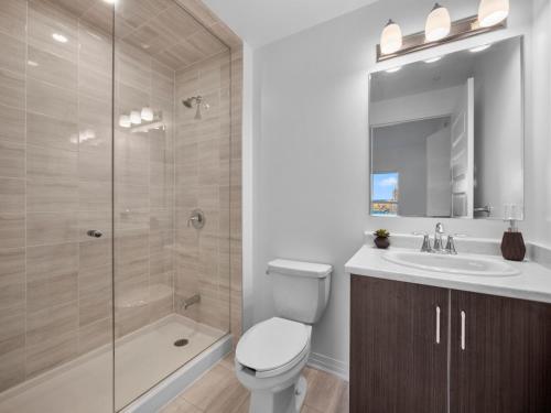 a bathroom with a toilet and a sink and a shower at Stylish 3Br + Study Condo - Oakville in Oakville