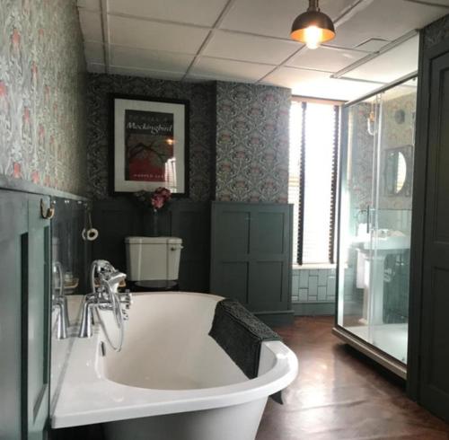 a large bathroom with a tub and a sink at Pondside Cottage in Carmarthen
