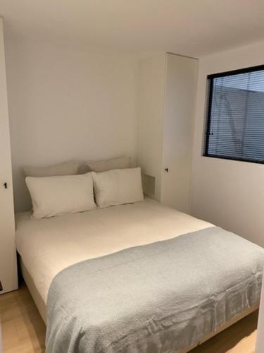 een wit bed in een kamer met een raam bij Royal Knokke in Knokke-Heist