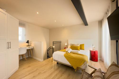 a bedroom with a bed with yellow sheets and a desk at BARCELONA TOUCH APARTMENTS - Progres in Hospitalet de Llobregat