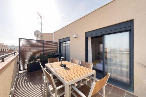 a wooden table and chairs on a balcony at BARCELONA TOUCH APARTMENTS - Progres in Hospitalet de Llobregat