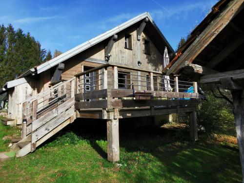 a large wooden house with a porch on top at Gite de la Bourbatte in Gerbamont 