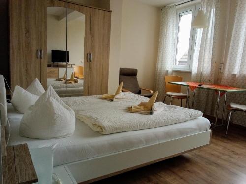 a bedroom with a large white bed with a mirror at Hotel Ratscafe Ückeritz in Ueckeritz