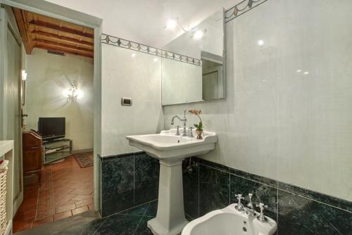 łazienka z umywalką, lustrem i toaletą w obiekcie Pergola Apartment we Florencji