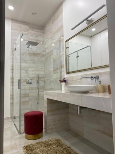 a bathroom with a sink and a shower with a mirror at Old town apartment in Kaunas