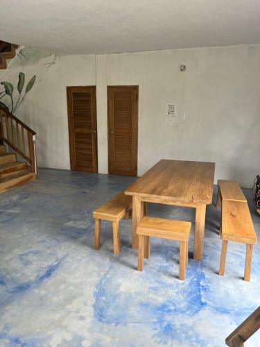 een houten tafel en banken in een kamer bij Rainbow Hostel in San Bernardo del Viento