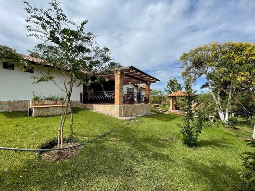 a yard with a house with a hose at Casa de campo Villa Tatiana- Mesa de Los Santos in Los Santos
