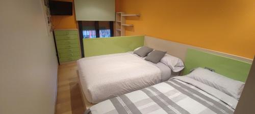 a small bedroom with a bed and a mirror at Piso Estación Termal II in Ourense