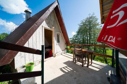a small cabin with a table and a chair on a porch at Dobre Vode 2 in Žabljak