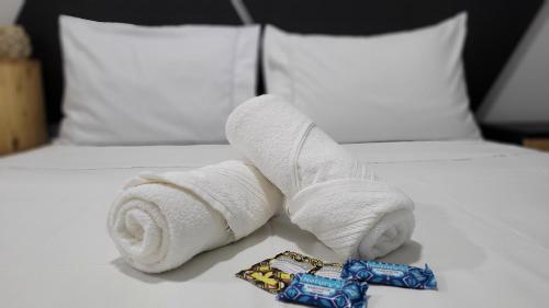 una pila de toallas sentadas encima de una cama en Pousada Al Mare en Balneario Camboriú
