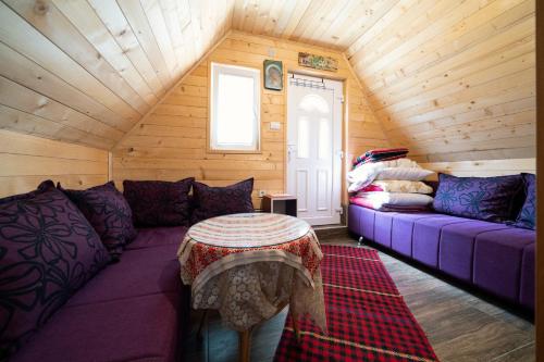 ein Wohnzimmer mit einem lila Sofa und einem Tisch in der Unterkunft Dobre Vode 2 in Žabljak