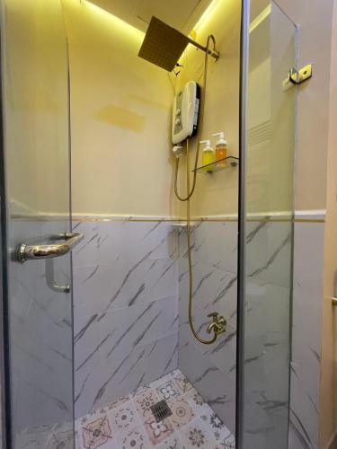 a shower with a glass door and a phone at SMDC Trees Residences Tower 1 - 2BR Newly Renovated Staycation in Manila