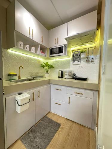 a kitchen with white cabinets and a sink at SMDC Trees Residences Tower 1 - 2BR Newly Renovated Staycation in Manila