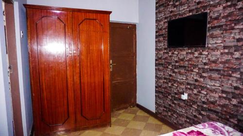 a wooden door in a room with a brick wall at LUSHOTO EXECUTIVE LODGE in Lushoto