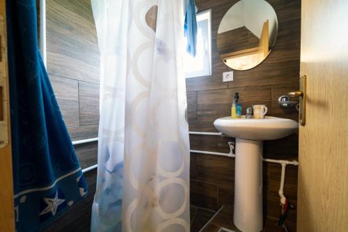 a bathroom with a sink and a shower curtain at Dobre Vode 2 in Žabljak