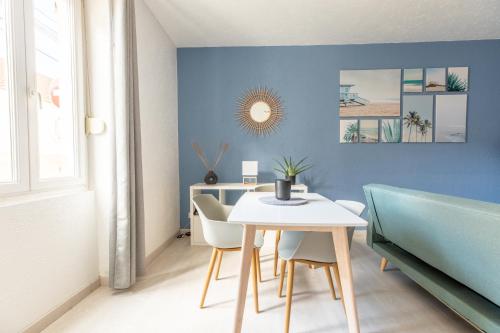 uma sala de jantar com paredes azuis e uma mesa e cadeiras em Cosy T2 rénové, proche centre-ville-Fibre/Netflix em Montluçon