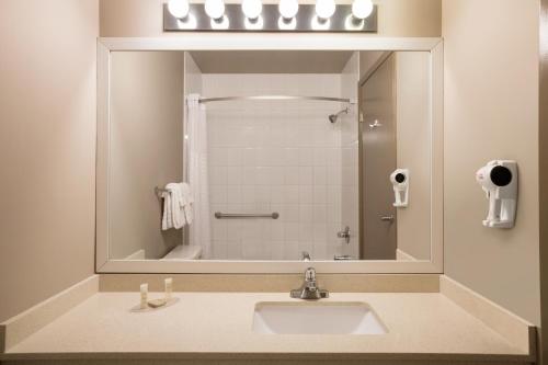 a bathroom with a sink and a large mirror at Days Inn by Wyndham Woodstock in Woodstock