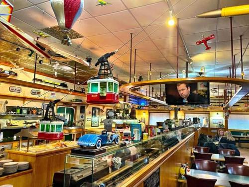 um restaurante com carros de brinquedo em exposição e uma televisão em 3-Br 2-Bath Family-Friendly Home -10 Min to Tulsa em Tulsa