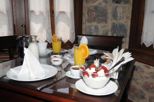 a table with plates of food and fruit on it at Archontiko Hatzipanayioti in Leonidion
