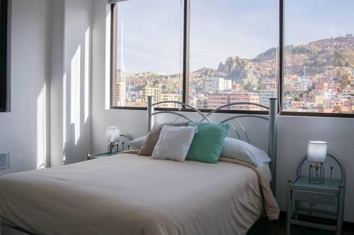 a bedroom with a bed with a view of a city at Sky Suites - Fantastic Apt in the heart of La Paz in La Paz