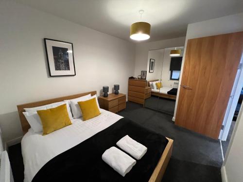 a bedroom with a large bed with yellow pillows at Stunning City Centre Apartment, Benson Street, Liverpool 1 in Liverpool