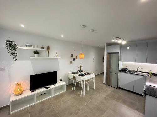 a kitchen and living room with a table and a television at Brand New - Massive Studio - E1 - Self Catering in Gibraltar