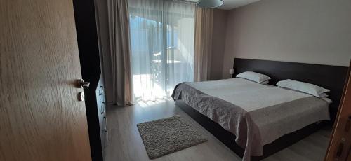 um quarto com uma cama e uma grande janela em Villa Gardenia em Sapareva Banya