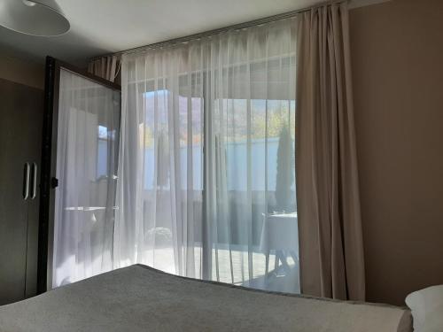 a bedroom with a window with a view of a patio at Villa Gardenia in Sapareva Banya