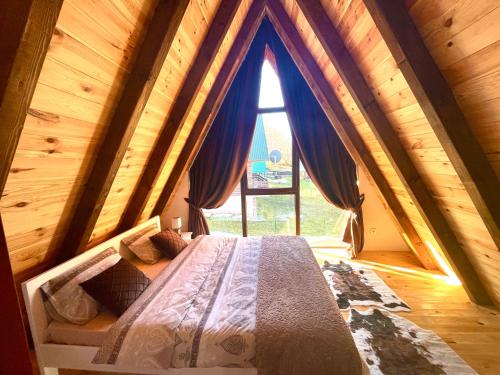 a bed in a room with a large window at Lux Villas Zabljak in Žabljak