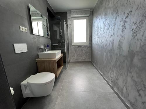 uma casa de banho com um WC e um lavatório em BonApart em Bedburg