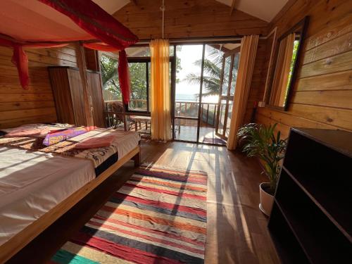 a bedroom with a bed and a rug on the floor at Sonho do Mar in Agonda