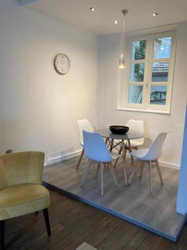 une salle à manger avec une table, des chaises et une horloge dans l'établissement l'Etape des Châteaux le 2 bis, à Meung-sur-Loire