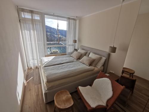 um quarto com uma cama e uma grande janela em HEARTH HILL VIEW APARTMENT em Ustroń
