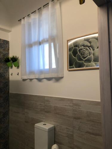 a bathroom with a toilet and a window at Narciso Katane suites in Catania