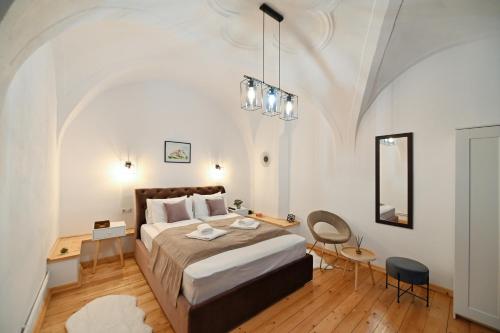 um quarto com uma cama, uma mesa e uma cadeira em Althof Apartments em Sibiu