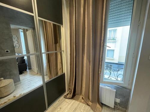 einen großen Spiegel in einem Zimmer mit Fenster in der Unterkunft Le sacré cœur in Paris