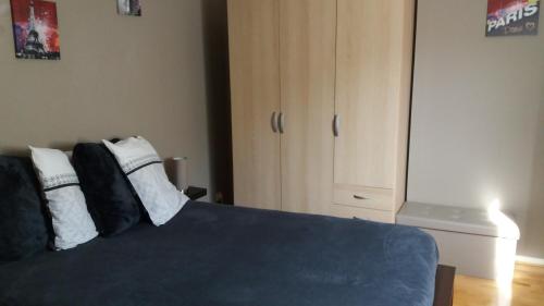 a bedroom with a blue bed and a white cabinet at Meublé de tourisme 2* les Jardins de l Arquebuse in Dijon