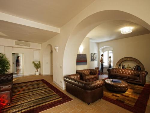 a living room with leather furniture and an archway at Hotel Sorella Luna in Assisi