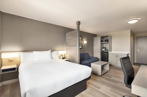 a hotel room with a bed and a kitchen at Microtel Inn & Suites Dorval QC in Dorval