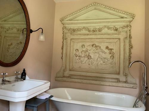 a bathroom with a sink and a tub and a mirror at Barns Library in Peebles