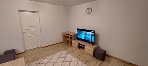 Una sala de estar con un televisor de pantalla plana en una pared. en Pelguranna Apartment, en Tallin