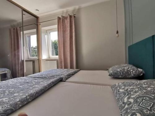 a bedroom with two beds and a window at Apartamenty Motyl in Bytom