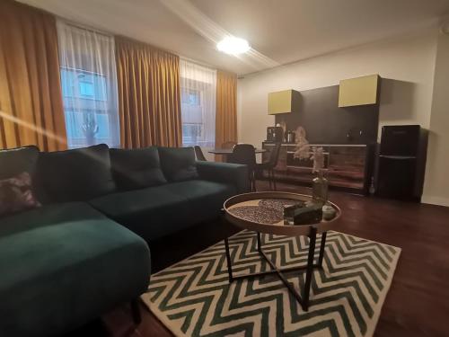 uma sala de estar com um sofá e uma mesa em Apartamenty Motyl em Bytom