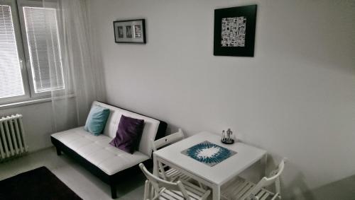 a living room with a white couch and a table at Hotel Terek in Štětí