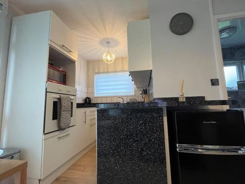 a kitchen with a black and white counter top at Chalet 59 Florida Holiday Park Hemsby in Hemsby