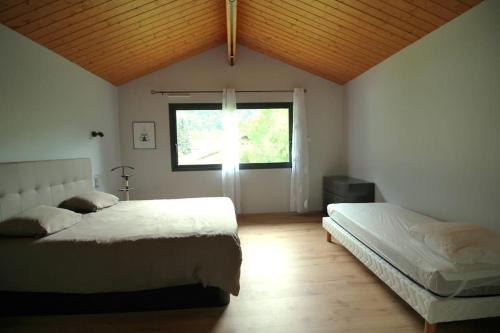 une chambre avec deux lits et une fenêtre dans l'établissement Grande villa contemporaine proche randonnée et ski, à Vicdessos