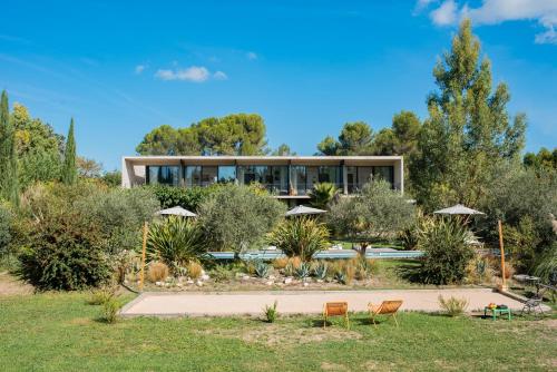 a house in a garden with chairs and umbrellas at Maison Jalon in Aix-en-Provence