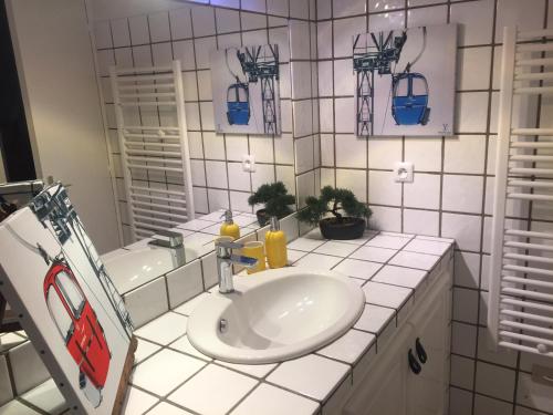 une salle de bain blanche avec un lavabo et un miroir dans l'établissement Serre Chevalier Chantemerle T2 + coin montagne en RDC pour 6 personnes, à Saint-Chaffrey